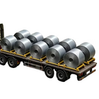 A miniature model flatbed truck carrying several large silver metal rolls, positioned in front of a small gray warehouse building on a gray concrete surface.