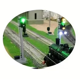 Five green electronic circuit board modules with attached wires are shown on a white background, with three circular inset photos at the bottom demonstrating model train signal and track applications.